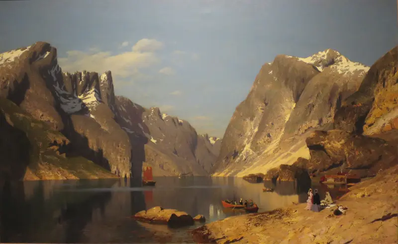 A vast fjord landscape with towering mountains, a red-sailed boat, and figures on the rocky bank.