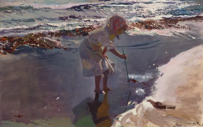A young girl in a pale striped dress and red kerchief bends over the wet sand at the water’s edge holding a long stick, with foamy surf and seaweed behind her.