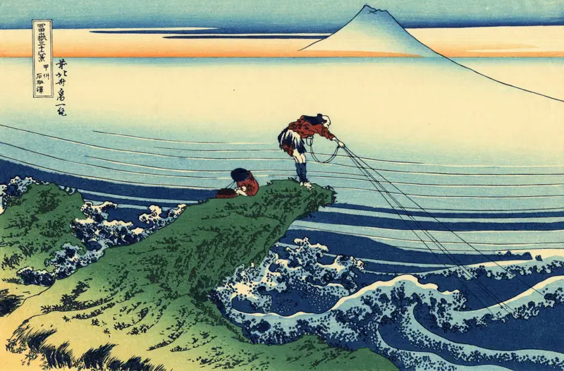 Two fishermen in red garments stand and crouch on a jagged green promontory above foaming blue and white waves with Mount Fuji visible in the distance.