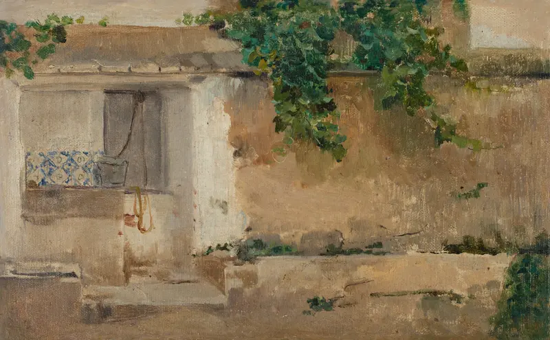 A sunlit ochre and cream plaster courtyard wall with a small window, blue and white tiled sill, a metal bucket, yellow cloth, steps, and green foliage spilling over the top.