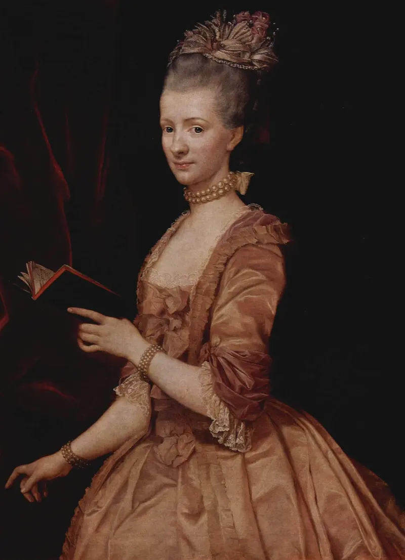 A poised woman in a rose-gold gown holding an open book, with pearls and a feathered headdress.