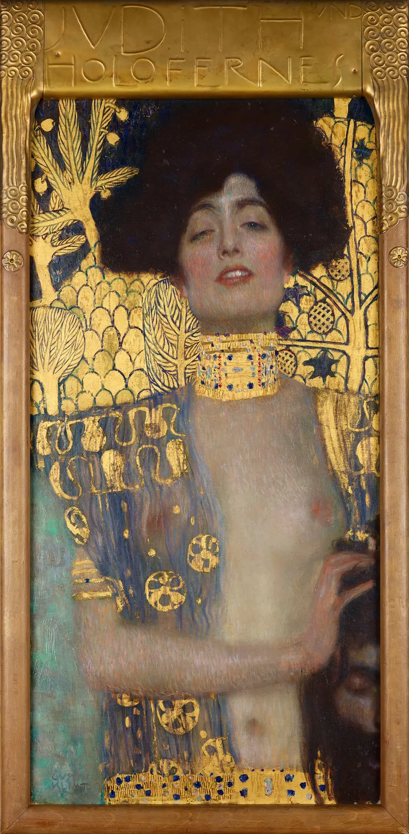A waist-up portrait of Judith with dark hair halo, pale skin, and a raised hand holding a severed head against a gold-patterned background.