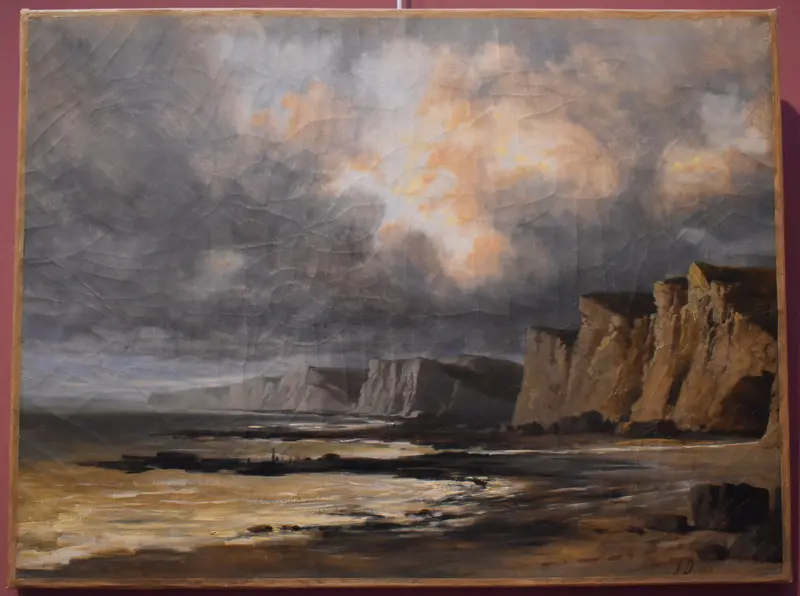 A dramatic landscape featuring cliffs illuminated by golden light against a turbulent sky.