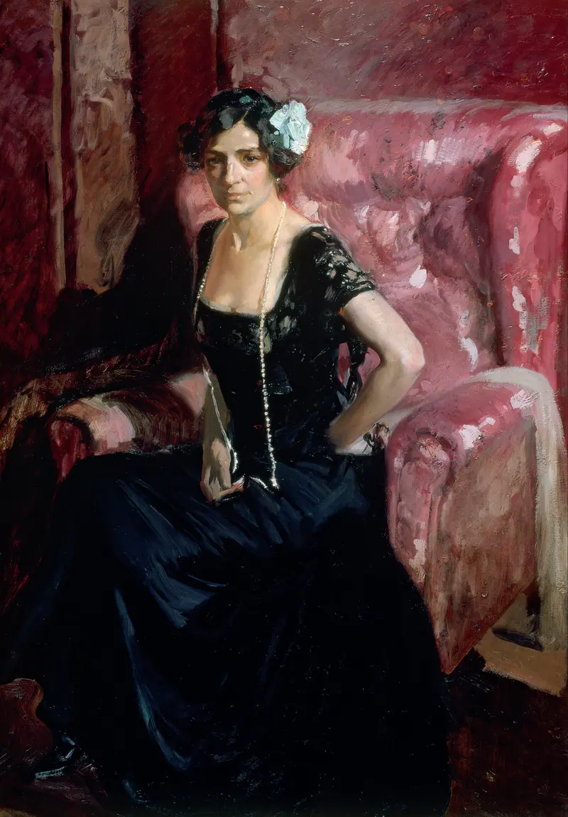 A woman in a black evening dress sits upright in a large pink armchair against a textured red and pink background.