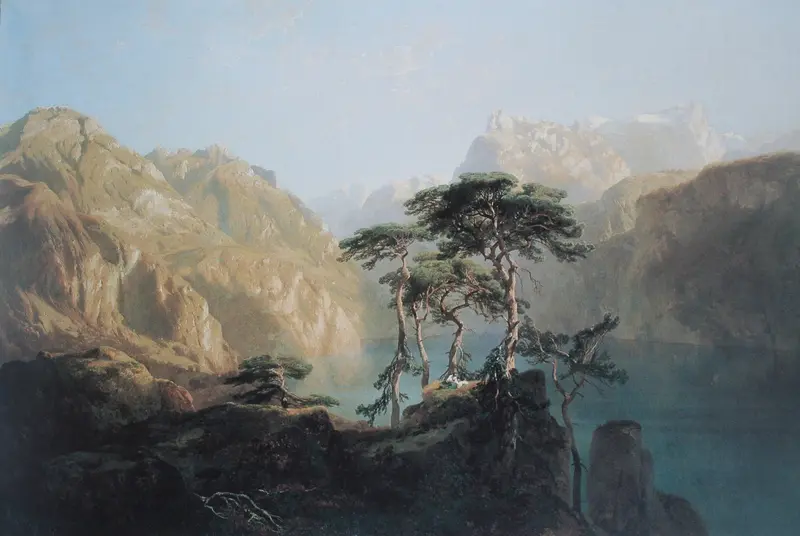 A cluster of wind-bent pines in the foreground with a shimmering blue lake and pale mountain ridges in the background.