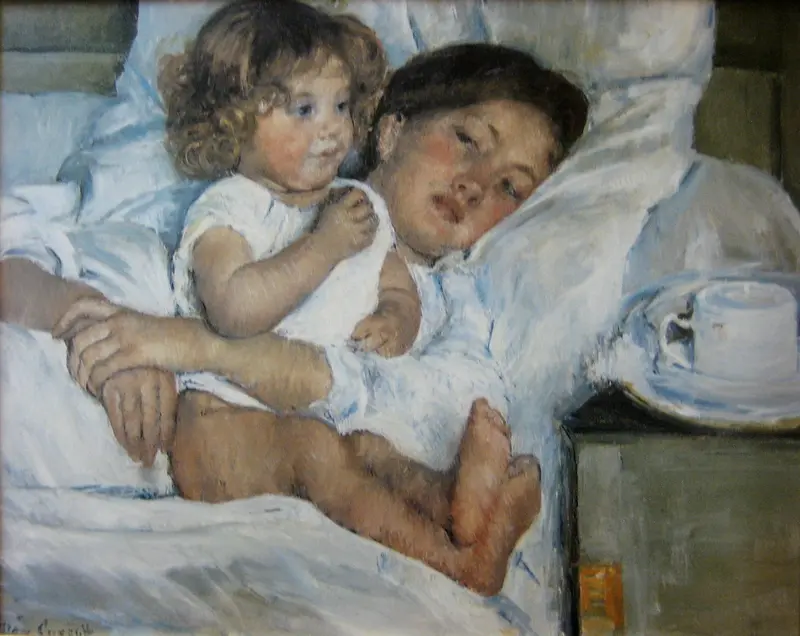 A mother and child share a quiet moment in a softly lit bedroom.