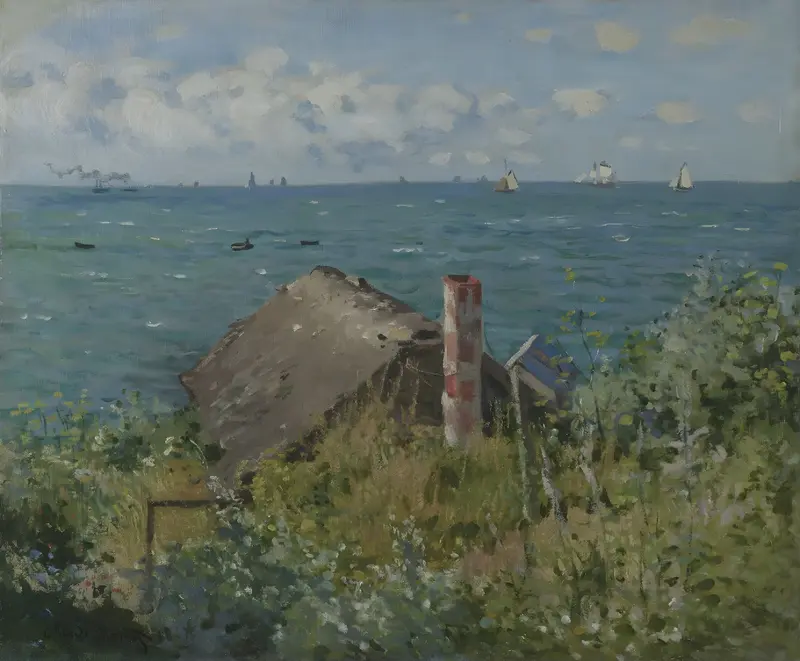 A weathered cabin with a red-striped chimney sits among tall grasses and wildflowers by a bluff overlooking the sea with boats and a cloudy sky.