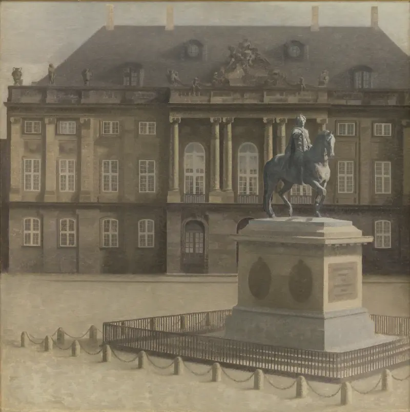 A solitary equestrian statue on a pedestal surrounded by a low iron fence stands in full sunlight at the center of a broad, empty square with the palace in the background.