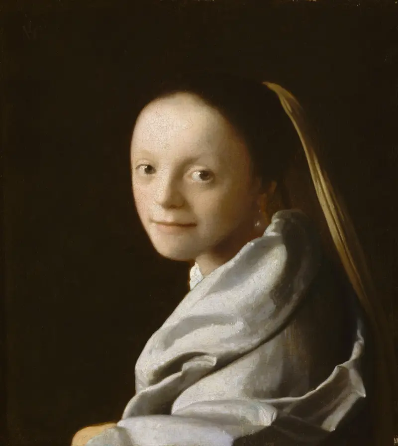 A young woman with a pearl earring and golden veil looks over her left shoulder against a dark background.
