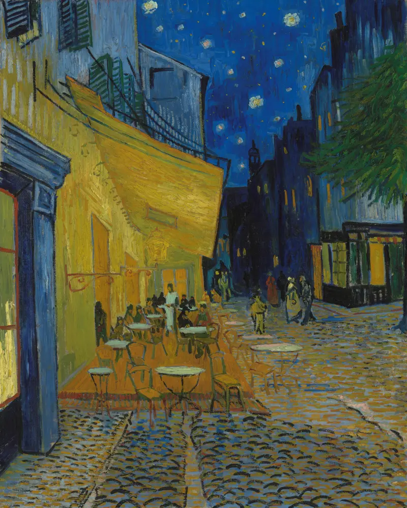 A brightly lit café terrace with tables, chairs, and small groups of people under a starry deep blue night sky on a cobbled street.
