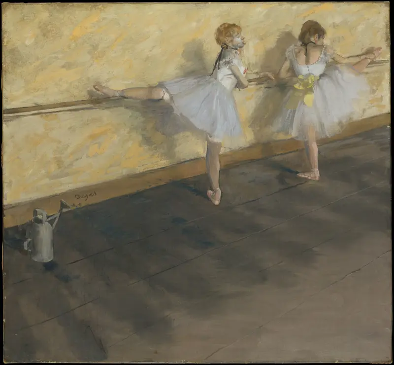 Two young dancers in white tutus stretch at a wooden barre in front of a yellow wall, with a metal watering can on the floor nearby.