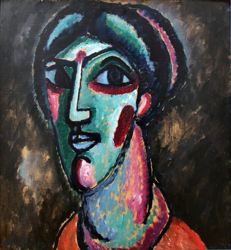 A face in bold colors, with deep-set eyes and a heavy brow, emerging from a dark background.