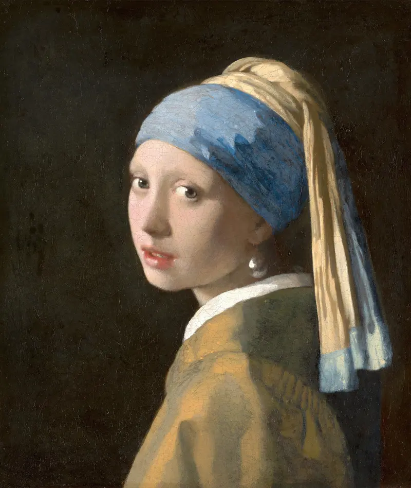A European girl wearing a blue headscarf with a yellow drape and a large pearl earring against a dark background.