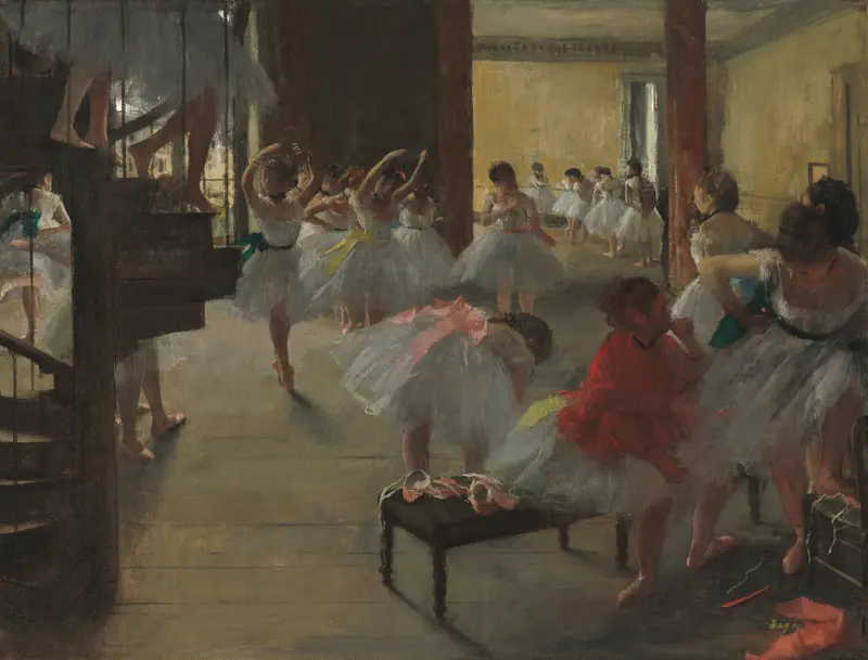 A group of young ballet dancers in white tutus with colored sashes practice in a sunlit studio framed by a dark spiral staircase.