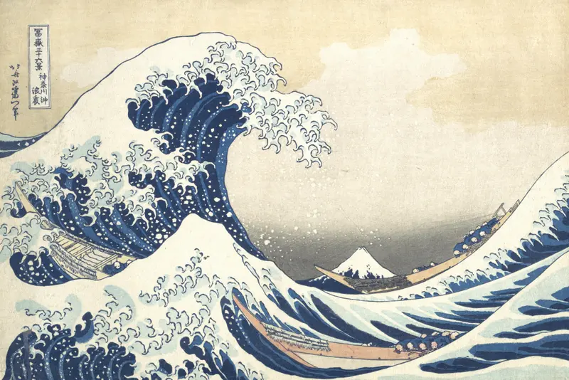 A large blue wave curls over three boats with figures, with Mount Fuji visible in the distant background under a muted sky.